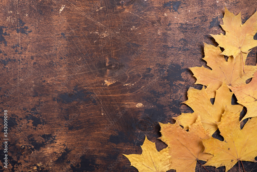 Dry maple leaves on old grunge wooden background texture Copy space Autumn concept