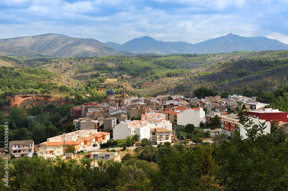 view of the town of Navajas, in Castellon, with fields, mountains and clouds in the background