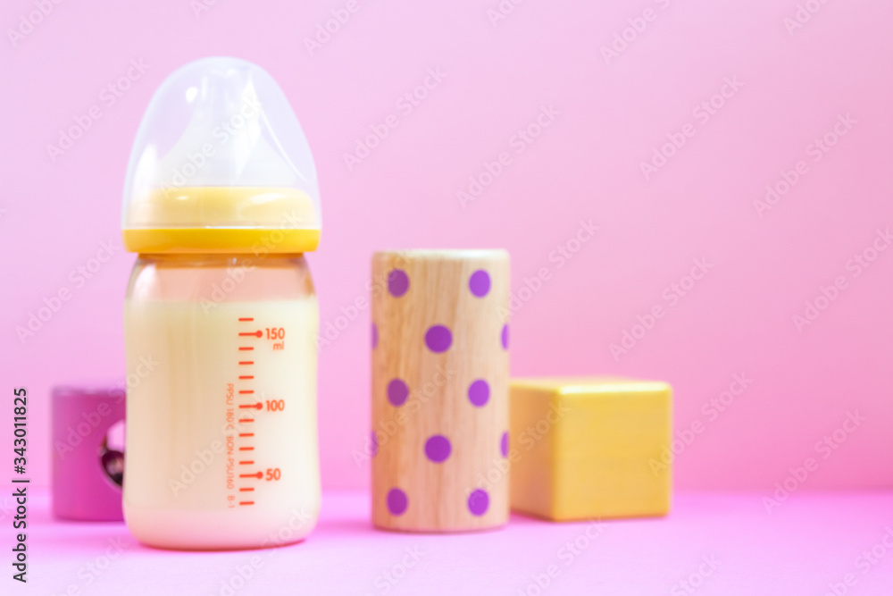 ピンクの背景と哺乳瓶とおもちゃ ピンクの背景と哺乳瓶とおもちゃ