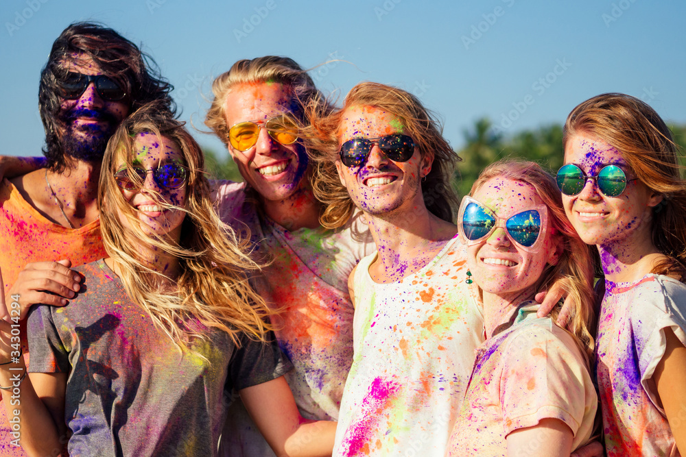 mixed race friends having fun with colors on seaside outdoors in Goa India mixed race friends having fun with colors on seaside outdoors in Goa India