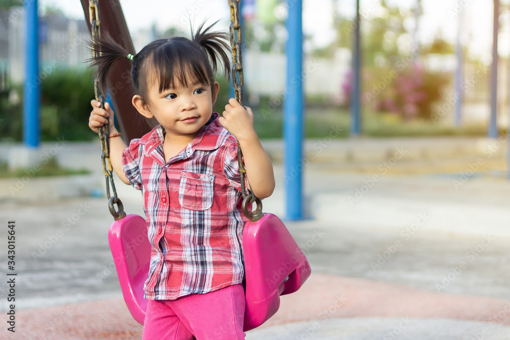 Portrait image of 1-2 years old baby. Happy Playful Asian child girl smiling and when she play the swing seat toy at the playground. Kids and development concept. Portrait image of 1-2 years old baby. Happy Playful Asian child girl smiling and when she play the swing seat toy at the playground. Kids and development concept.