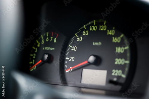 Close-up of the car dashboard, black speedometer, tachometer, with a red arrow indicating 0