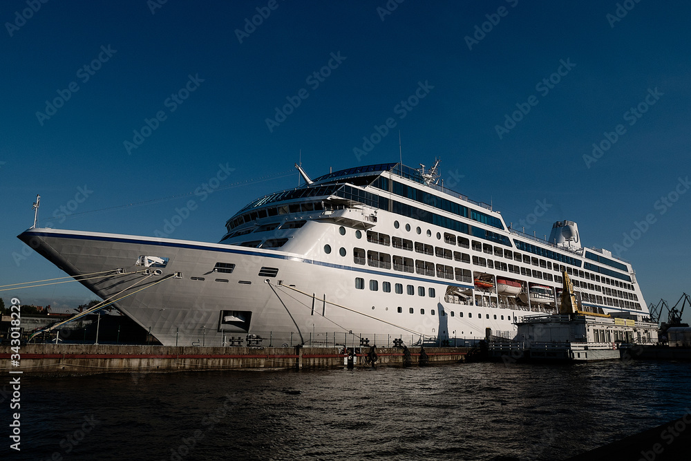 white liner stands in the port, sunset sky, blue water and sky