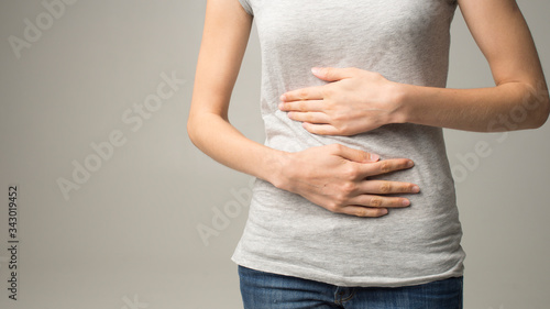 Young woman having painful stomachache. Chronic gastritis. Abdomen bloating concept
