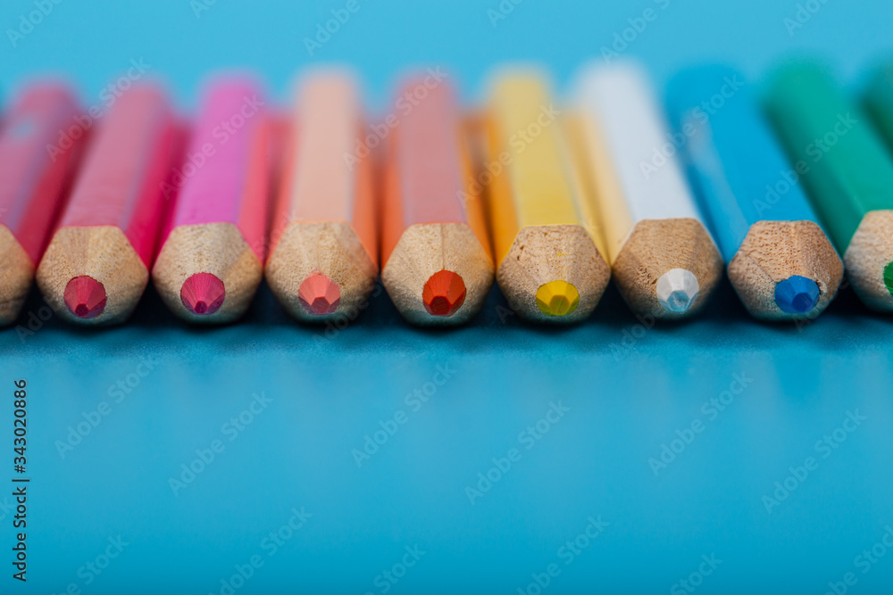 Close-up of set of colorful pencils on blue background with copy space Close-up of set of colorful pencils on blue background with copy space