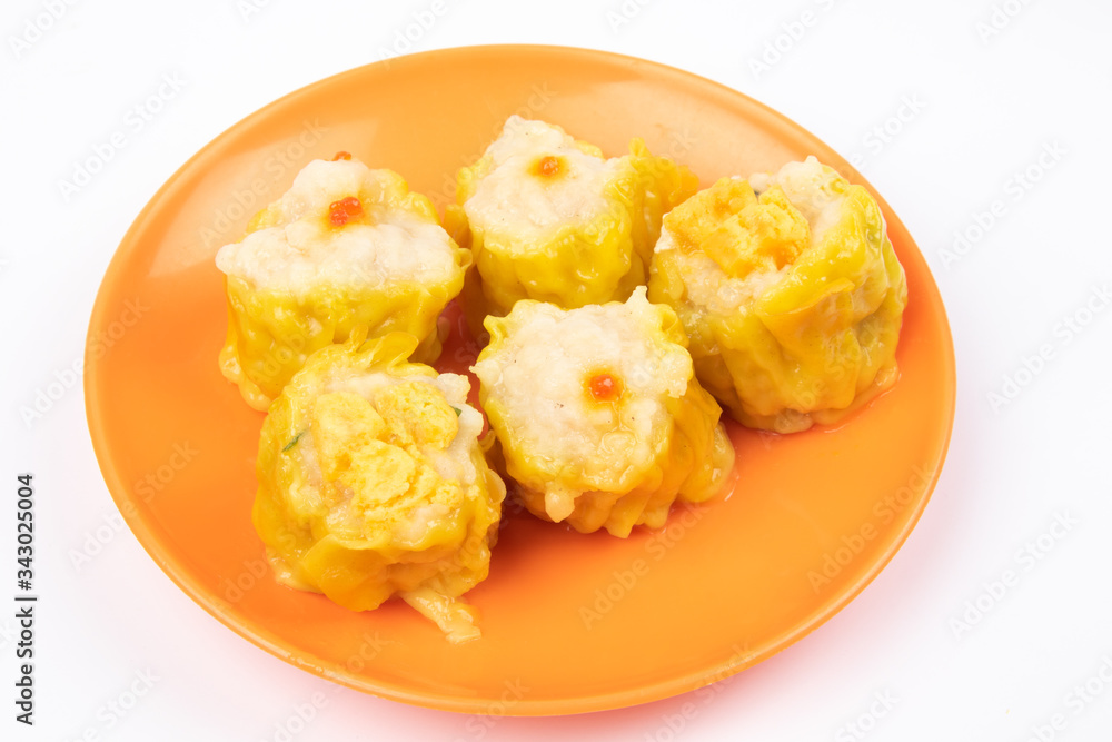 Siu Mai - Chinese steamed pork dumplings on plate isolated on white background.