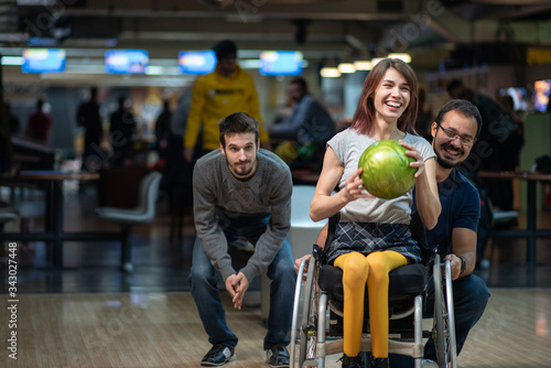 Disabled woman in a wheelchair bowling with friends