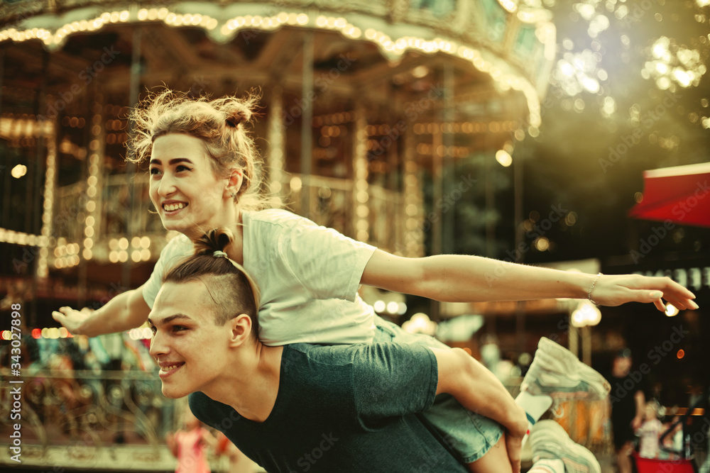 Young couple in love having fun together at amusement park Holidays, love and friendship concept