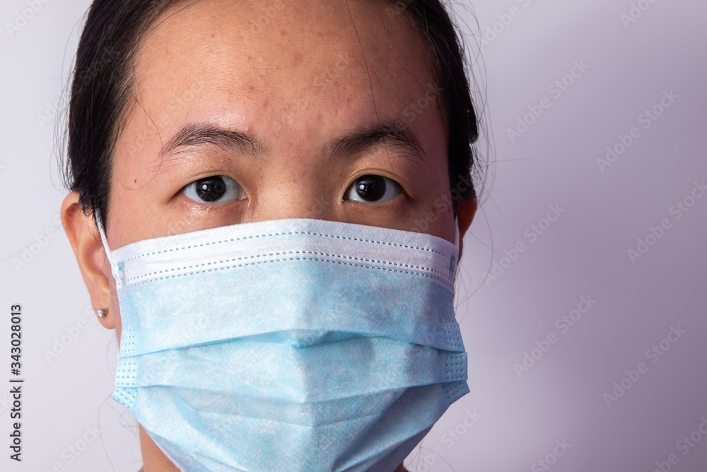 face of a Asian woman wearing surgical mask with expression face. Prevention of bacterial infection Corona virus or Covid 19 in a white background. face of a Asian woman wearing surgical mask with expression face. Prevention of bacterial infection Corona virus or Covid 19 in a white background.