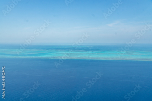 Great Barrier Reef Blue Ocean Sea view. Beautiful aqua & turquoise waters, with coral reef patterns in the ocean. View from helicopter, on vacation. Marine life, global warming, protection, island