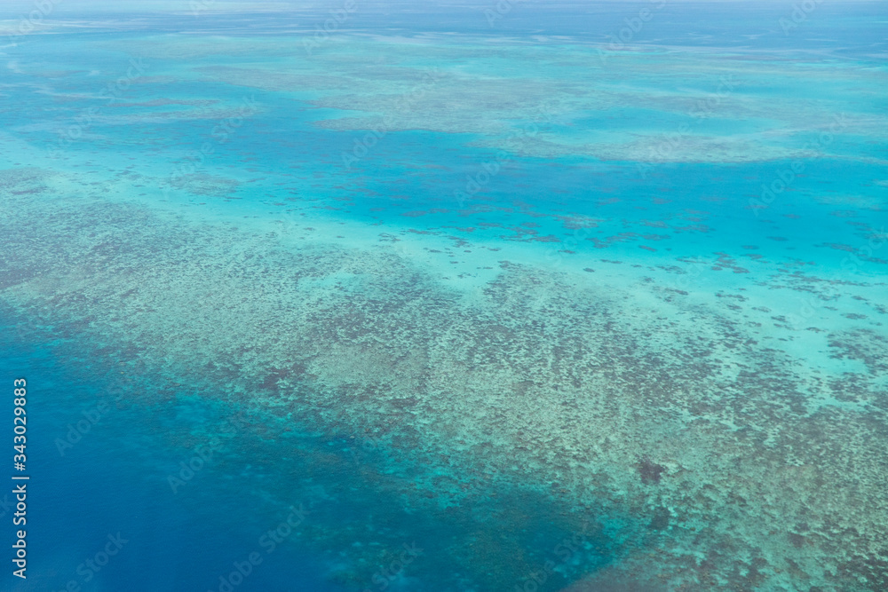 Great Barrier Reef Blue Ocean Sea view. Beautiful aqua & turquoise waters, with coral reef patterns in the ocean. View from helicopter, on vacation. Marine life, global warming, protection, island