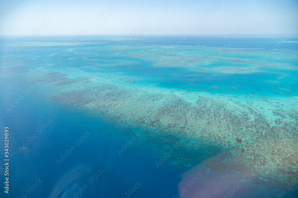 Great Barrier Reef Blue Ocean Sea view. Beautiful aqua & turquoise waters, with coral reef patterns in the ocean. View from helicopter, on vacation. Marine life, global warming, protection, island