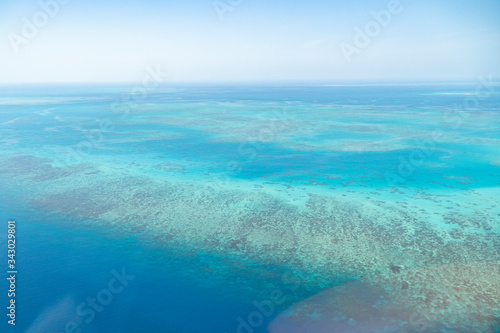 Fototapeta Naklejka Na Ścianę i Meble -  Great Barrier Reef Blue Ocean Sea view. Beautiful aqua & turquoise waters, with coral reef patterns in the ocean. View from helicopter, on vacation. Marine life, global warming, protection, island