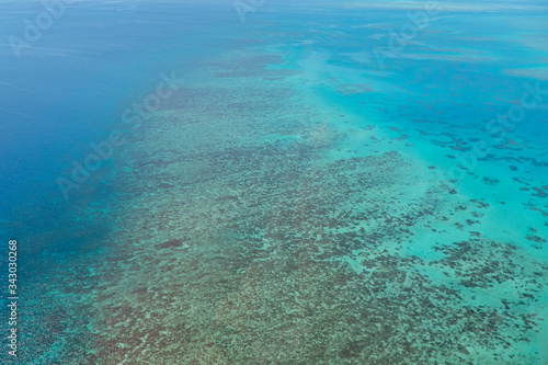 Great Barrier Reef Blue Ocean Sea view. Beautiful aqua & turquoise waters, with coral reef patterns in the ocean. View from helicopter, on vacation. Marine life, global warming, protection, island © Jam Travels