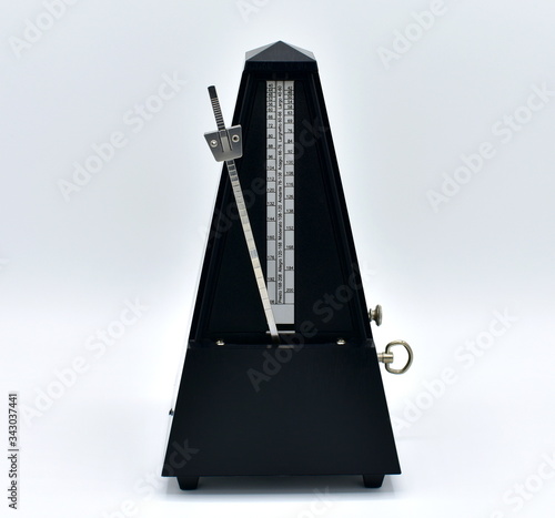 Black metronome isolated on a white background.