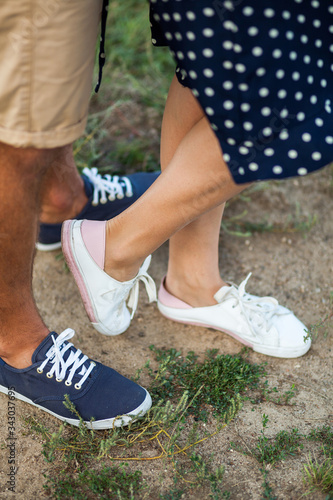 Young couple in love stading cross-legged outdoor in nice sunny da