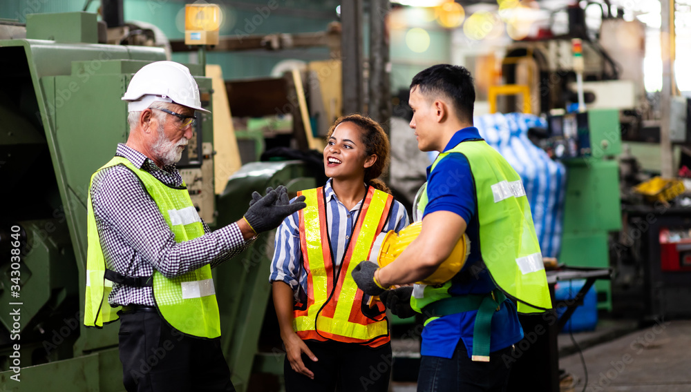 Man and Woman engineering wearing safety goggles and hard hats giving high five and celebrating success. Metal lathe industrial manufacturing factory Man and Woman engineering wearing safety goggles and hard hats giving high five and celebrating success. Metal lathe industrial manufacturing factory