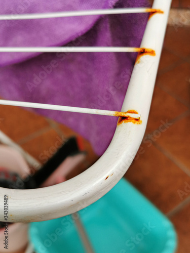  clothes dryer with rust and a purple rag on a background of a basin and a bucket, cleaning and work housekeeping, house maintenance