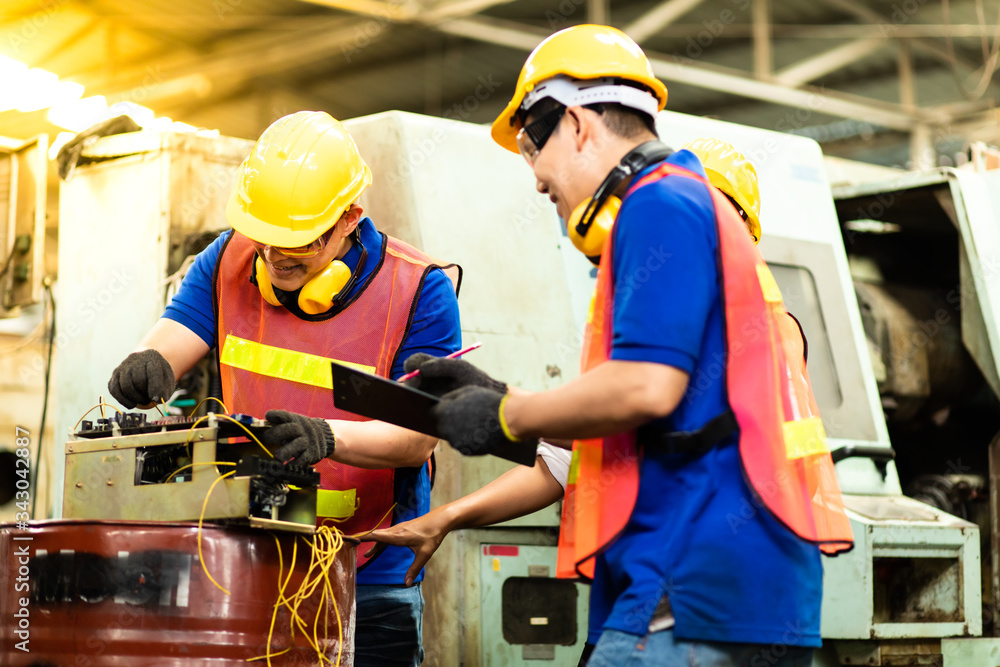 Professional Asian team engineering Man Worker at industrial factory wearing uniform and hardhats at Metal lathe industrial manufacturing factory. Engineer Operating lathe Machinery Professional Asian team engineering Man Worker at industrial factory wearing uniform and hardhats at Metal lathe industrial manufacturing factory. Engineer Operating lathe Machinery