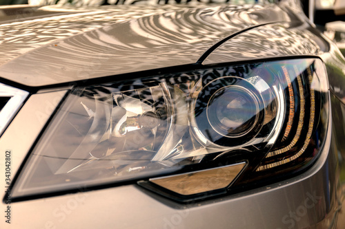 Headlight of modern prestigious car close up. Car headlight with shallow depth of field.