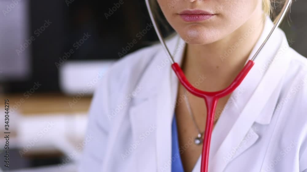 Female doctor using stethoscope in a medical center. close up view Female doctor using stethoscope in a medical center. close up view