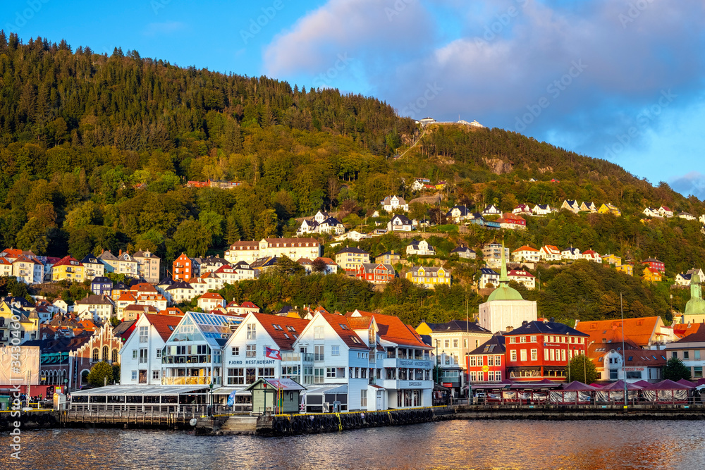 Bergen, Norway - Panoramic view of historic city center along Bryggen street at the Bergen harbor with Holy Cross church and Floyen Mountain in background