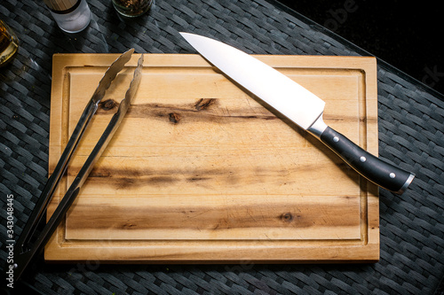 Holzbrett, Messer und Grillzange