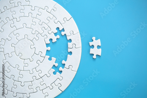 White jigsaw puzzle pieces on a blue background. Problem solving concepts. Texture photo with copy space for text photo