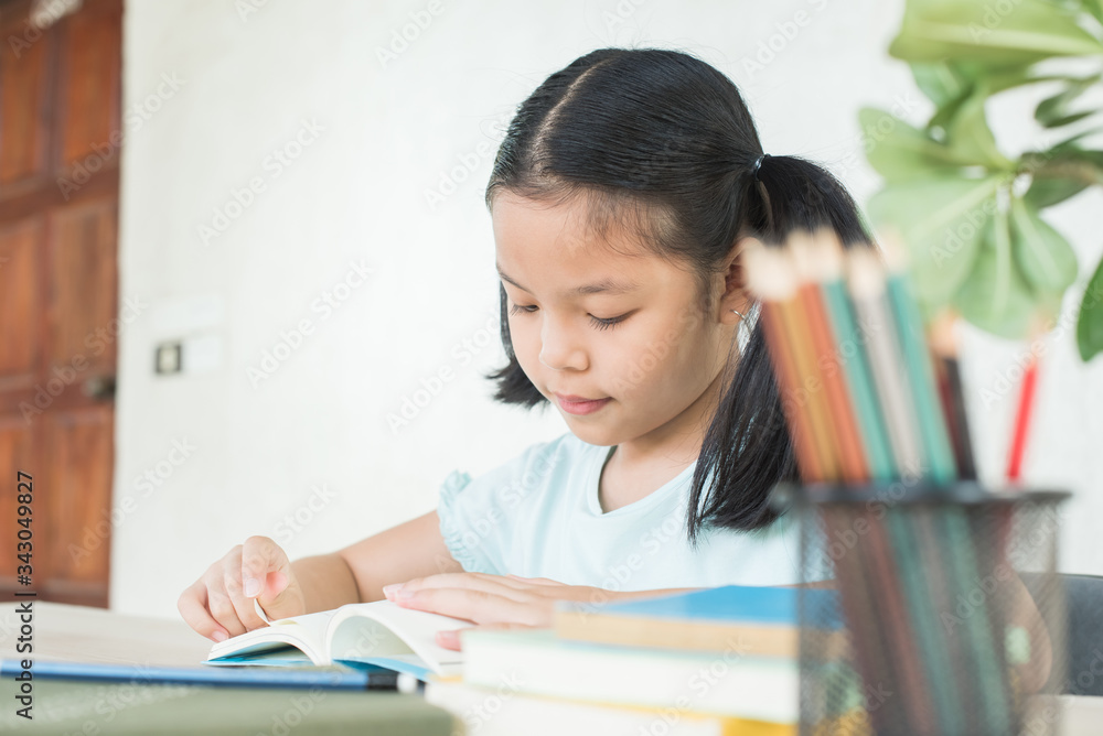 pretty stylish schoolgirl studying homework during online lesson at home, social distance during quarantine, self-isolation, online education concept, home school. girl does homework in her copybook pretty stylish schoolgirl studying homework during online lesson at home, social distance during quarantine, self-isolation, online education concept, home school. girl does homework in her copybook