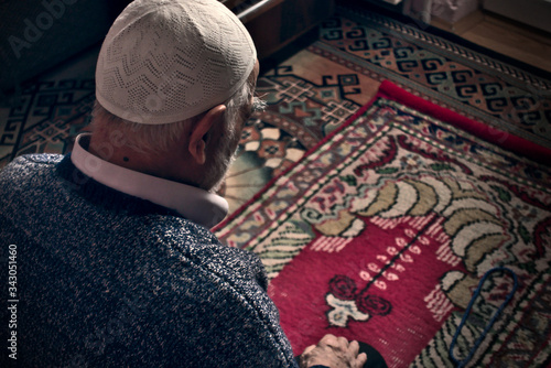 Foto Very old Turkish muslim man doing Salah prayer at his home on his prayer rug