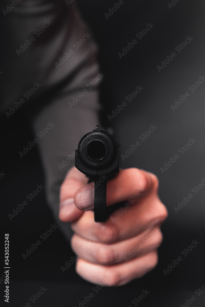 Male hand with gun isolated on black background. Man with a gun ready to shoot, focus on the weapon. Male hand with gun isolated on black background. Man with a gun ready to shoot, focus on the weapon.