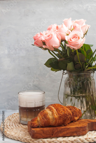 Romantic coffee break with croissant and roses