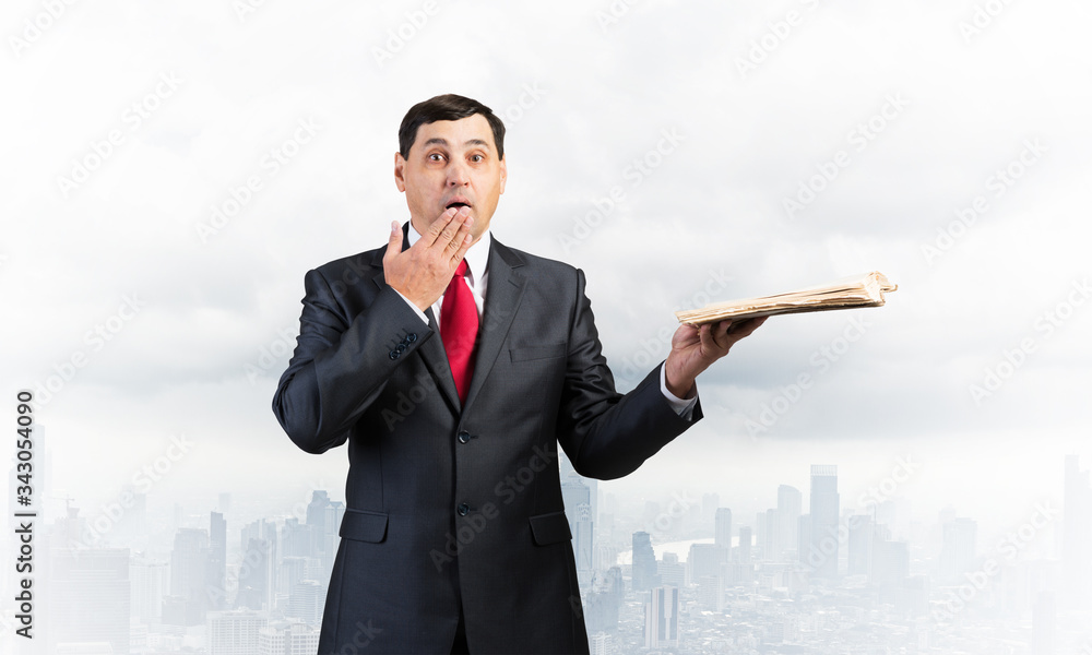 Embarrassed businessman covering mouth with hand Embarrassed businessman covering mouth with hand