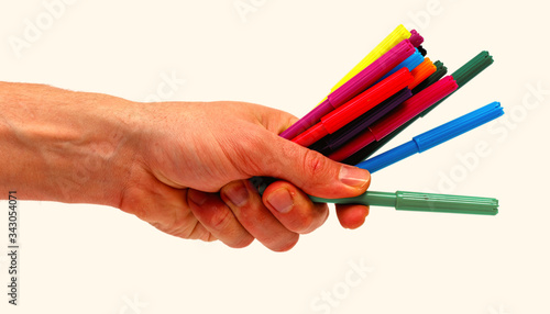 Male hand holding color marker pen isolated on white background. Minimalistic concept.