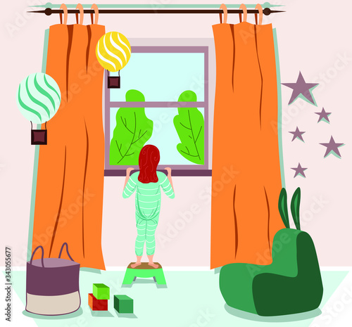 The child is standing at the window. Waiting in quarantine. Children's room with toys. Bored child