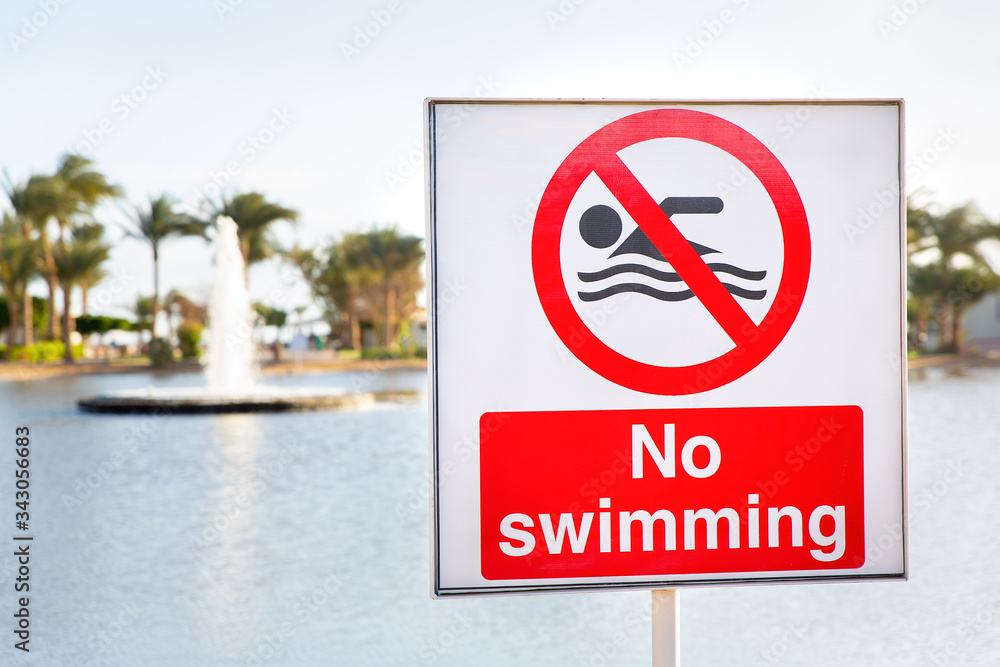 No swimming sign near water of pond No swimming sign near water of pond