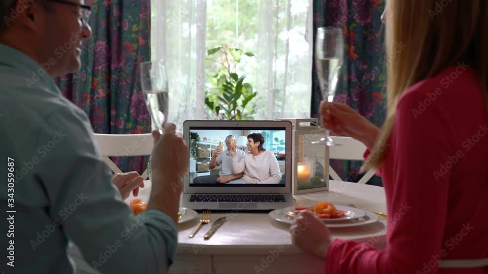 A young couple and an elderly couple celebrate together Using Laptop Video Call. Social distancing, self isolation during quarantine A young couple and an elderly couple celebrate together Using Laptop Video Call. Social distancing, self isolation during quarantine
