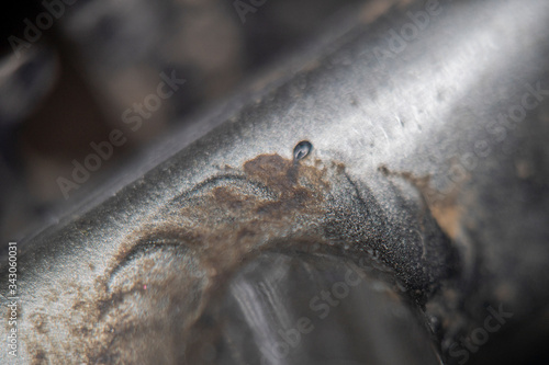 Blurred at high magnification photo of a weld seam coated with silver paint