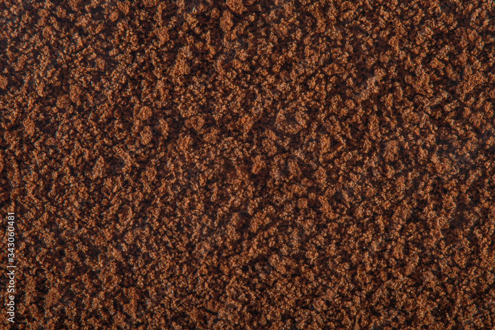 Brown background of sprinkled instant coffee with a strong increase Brown background of sprinkled instant coffee with a strong increase