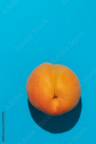 Ripe large apricot on a blue background.