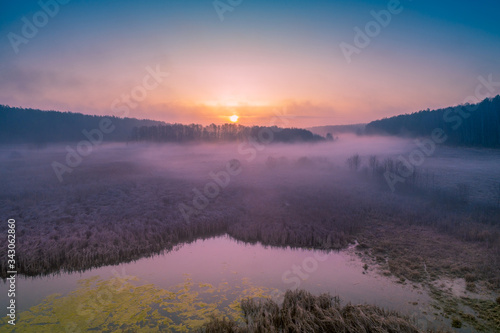 Early misty morning. Sunrise over countryside. Rural landscape in early spring. Aerial view
