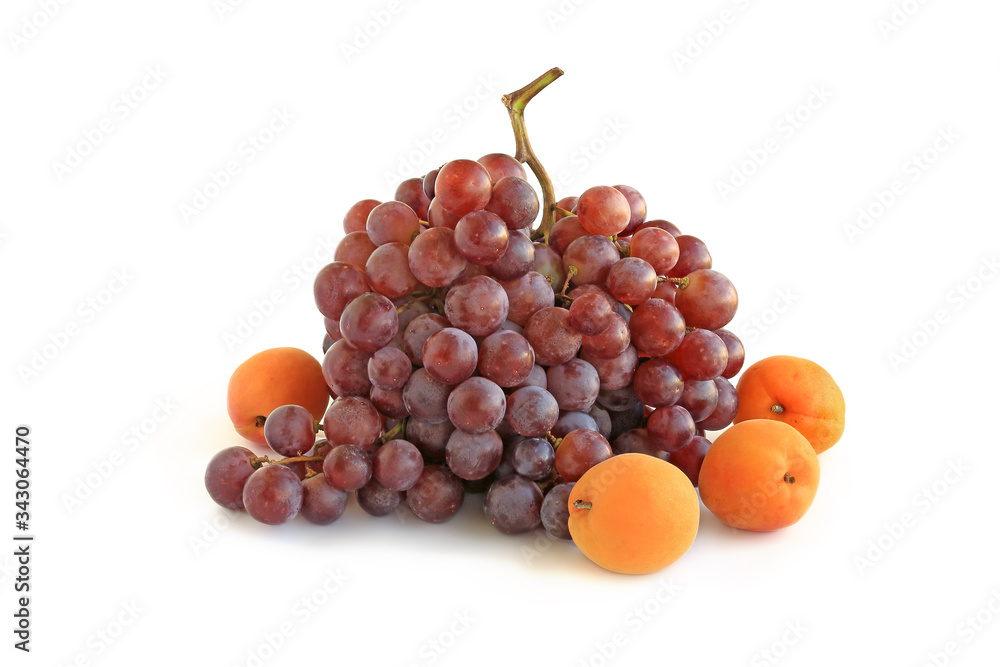 Bunch of purple grapes with apricots isolated on white Bunch of purple grapes with apricots isolated on white
