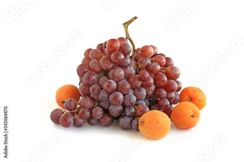 Bunch of purple grapes with apricots isolated on white