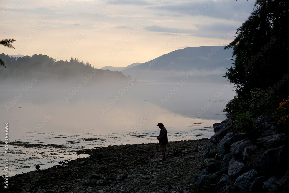 Anonymous silhouette of man in front of Lake in Scottish Highlands