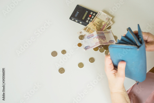 close-up of an elderly woman's hand counting coins Russian rubles on the background of a first-aid kit with medicines on a white table background place for text