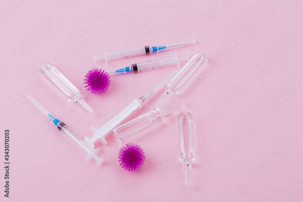Virus, syringe and ampoules with medicine on a pink background. Virus, syringe and ampoules with medicine on a pink background.