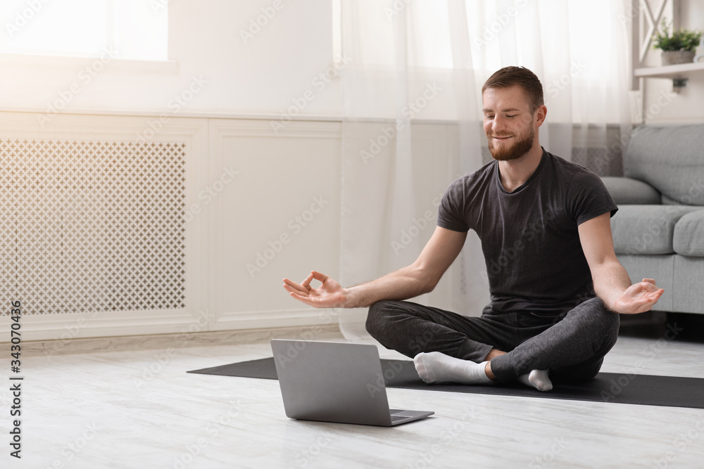 Millennial guy meditating with trainer online via laptop - obrazy, fototapety, plakaty 