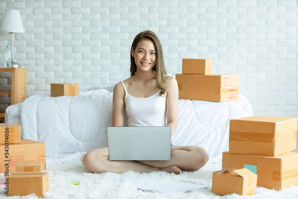 Small Business of young asian woman woking at home,Businesswoman working with laptop for Online shopping at home,Cheerful and Happy with box for order packaging in home,Own Business Start up concept Small Business of young asian woman woking at home,Businesswoman working with laptop for Online shopping at home,Cheerful and Happy with box for order packaging in home,Own Business Start up concept