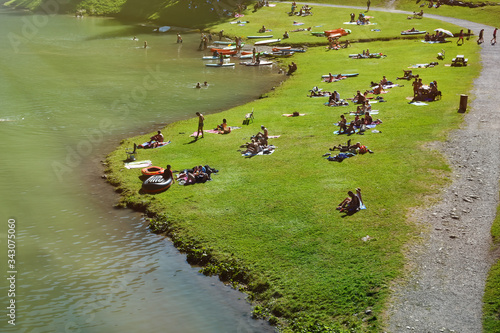 Leisure activity on the lake of Montriond, natural lake in Portes du Soleil, Haute - Savoie region, France, an attraction for many tourists, with swimming area, fishing, canoeing. photo