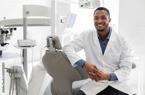 Highly qualified young dentist posing at modern clinic